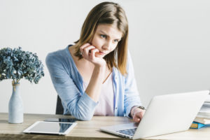 Mujer pensativa viendo la computadora